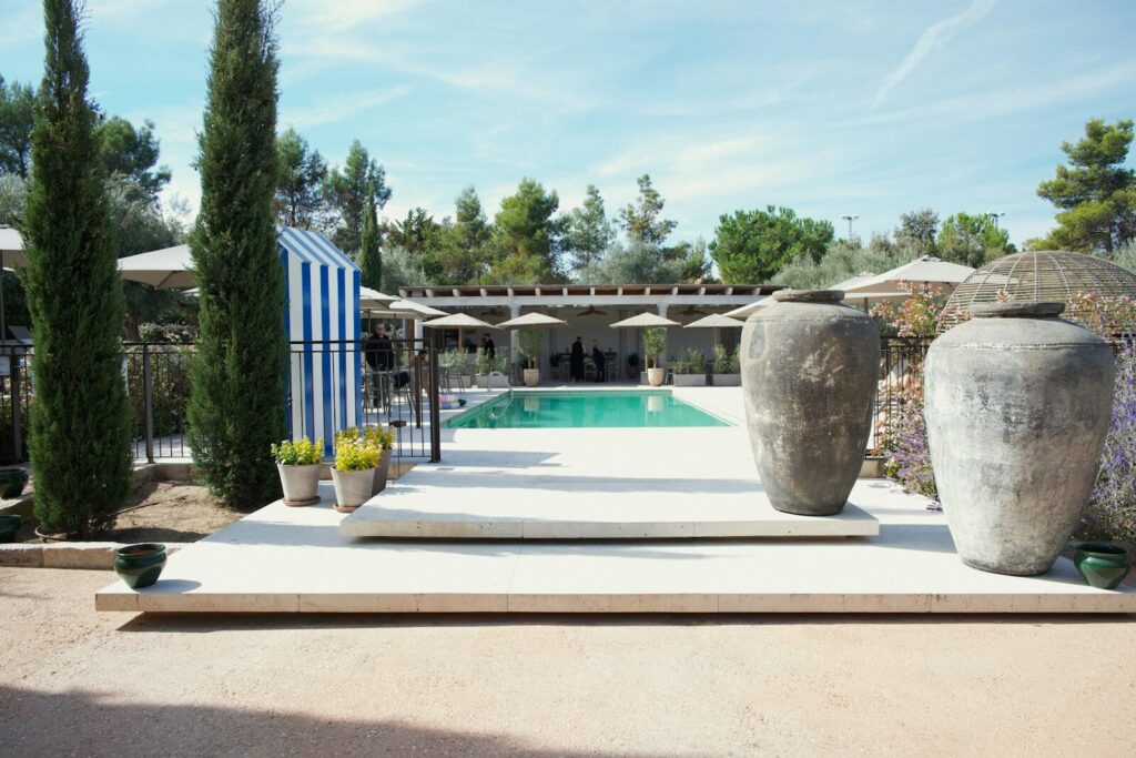 Two large urns flank a swimming pool area